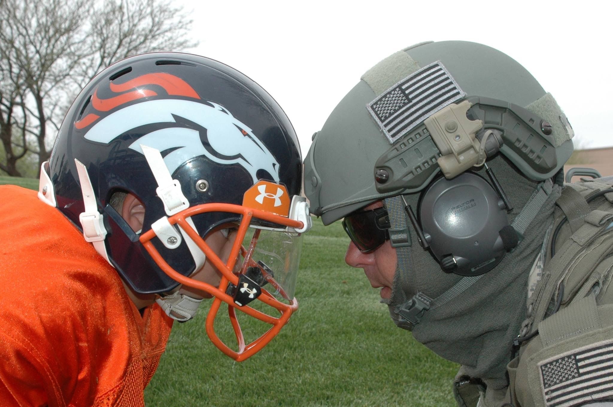 Young Football Player and SWAT police officer father, helmet to helmet