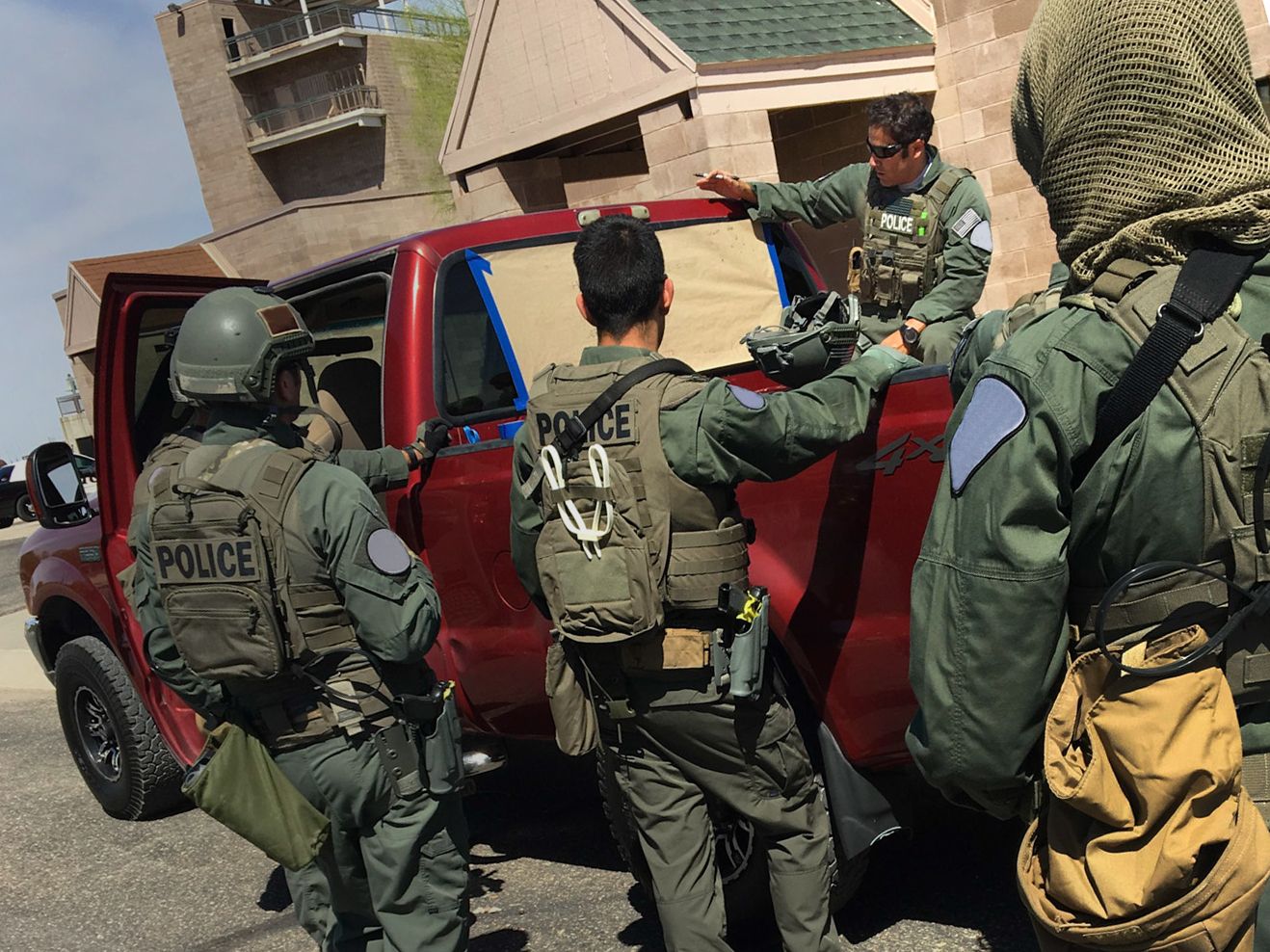 SWAT Small Unit training debriefing over the bed of a pickup truck