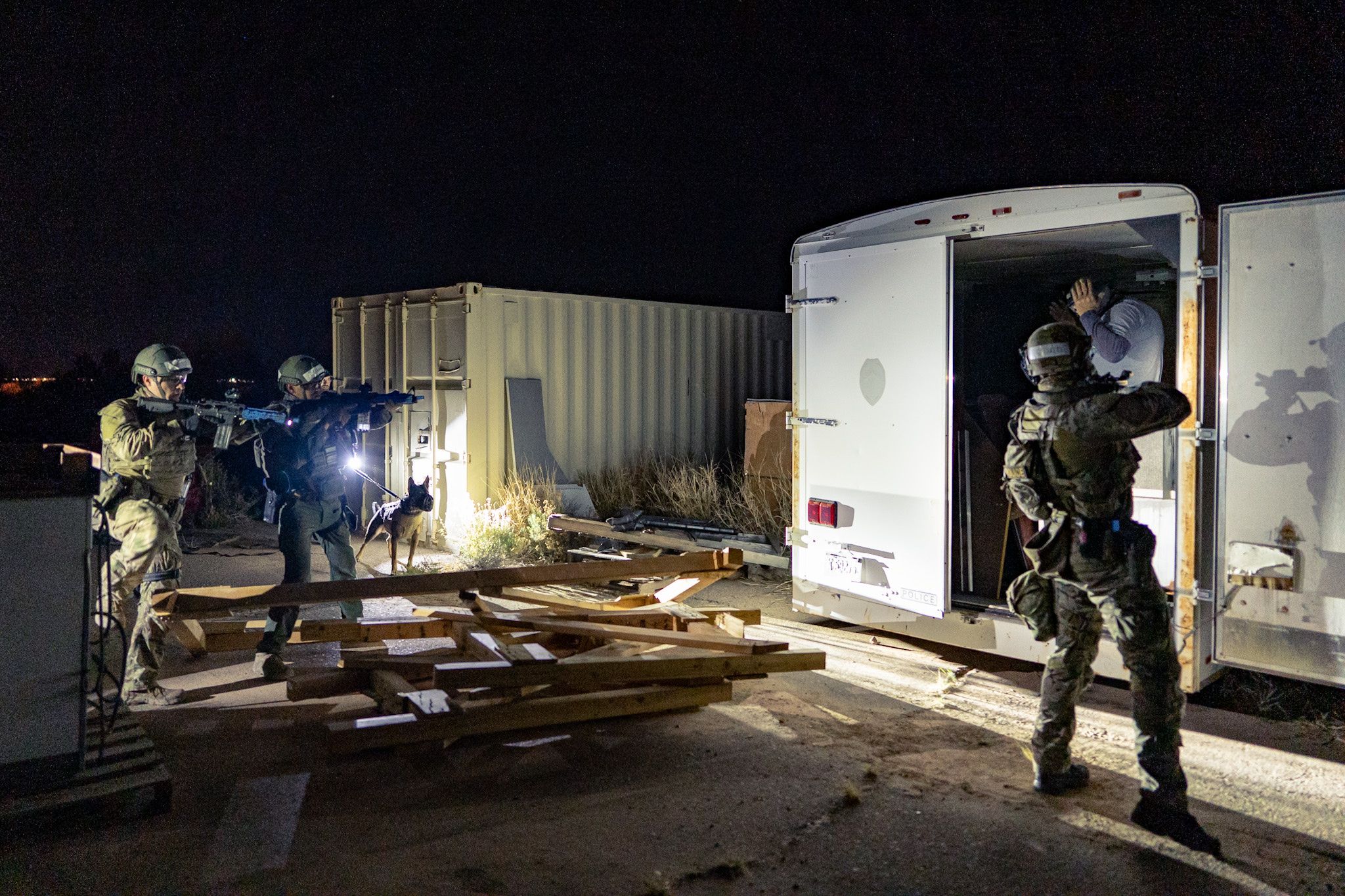 SWAT operators confront a suspect hiding in a trailer