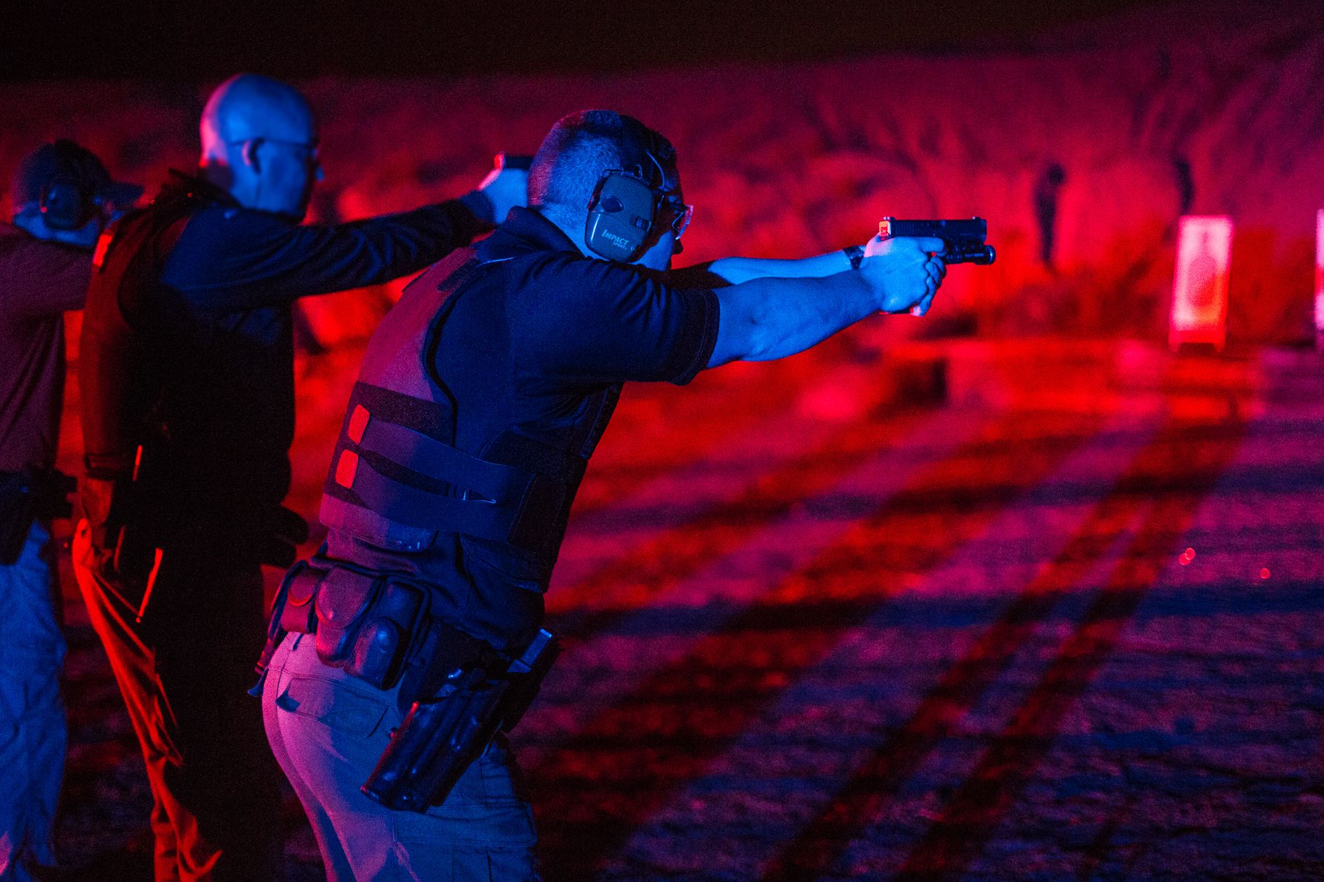 Police Officers training on the firing range at night with red and blue lights