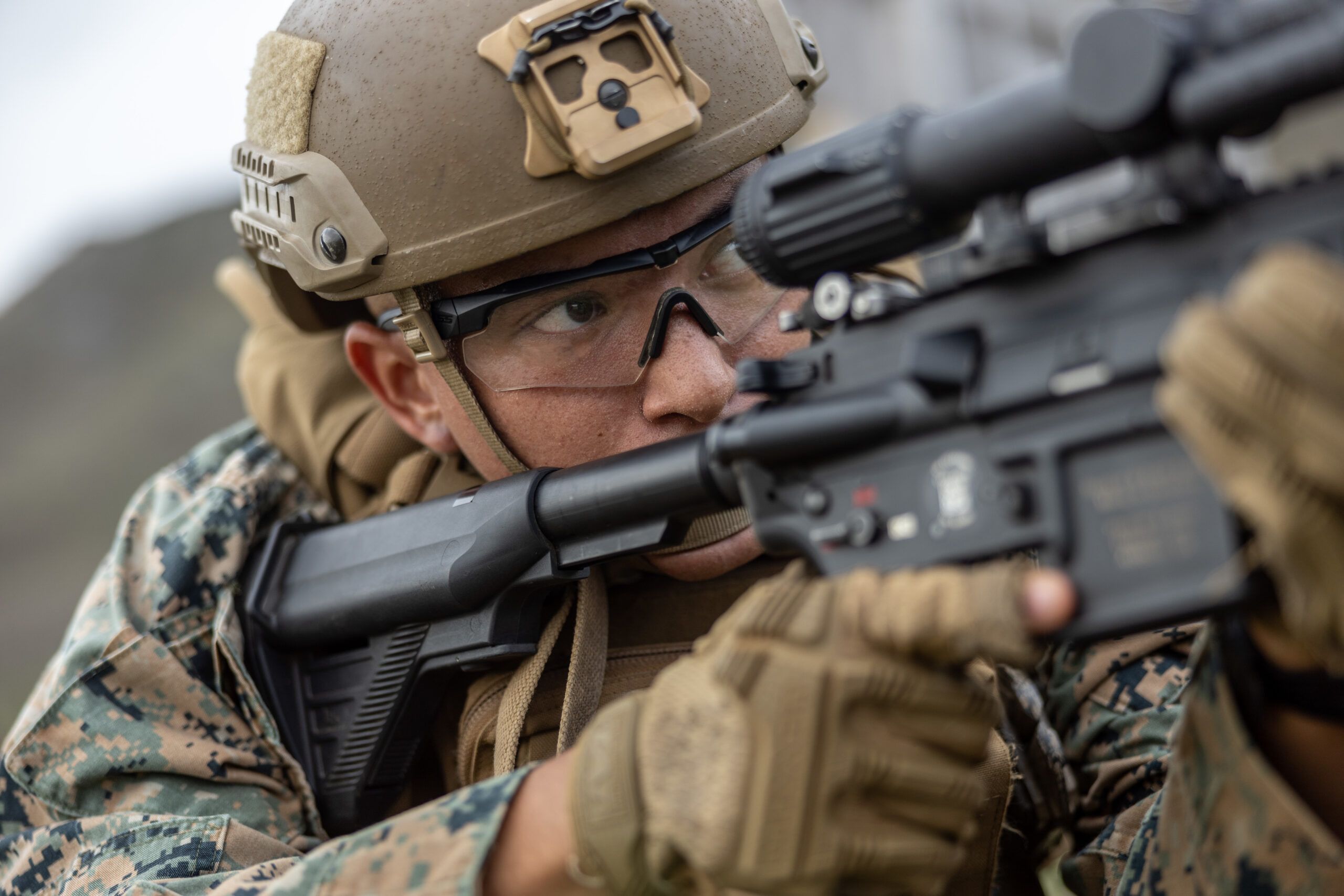 US Marine in digital camouflage uniform and body armor sighting in with his Infantry Automatic Rifle during a training exercise.