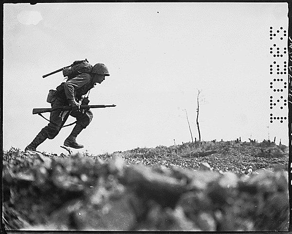 Infantry-man running across an open battlefield in black and white