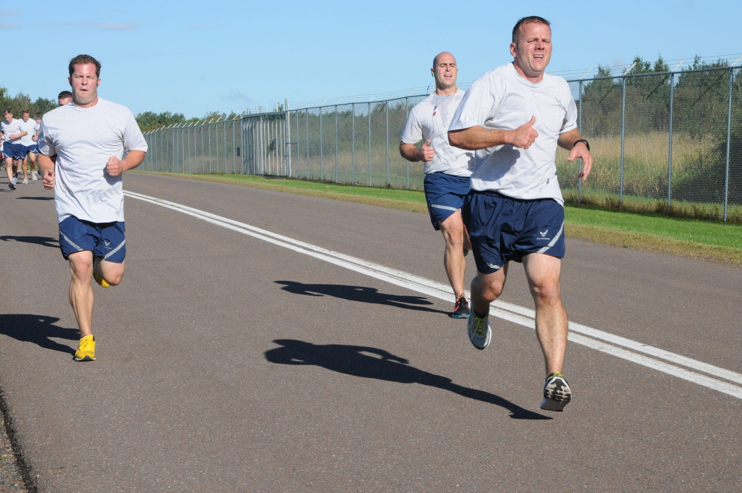 Airmen from the US Airforce running on a running trail in their Physical Training uniform shorts and t-shirt